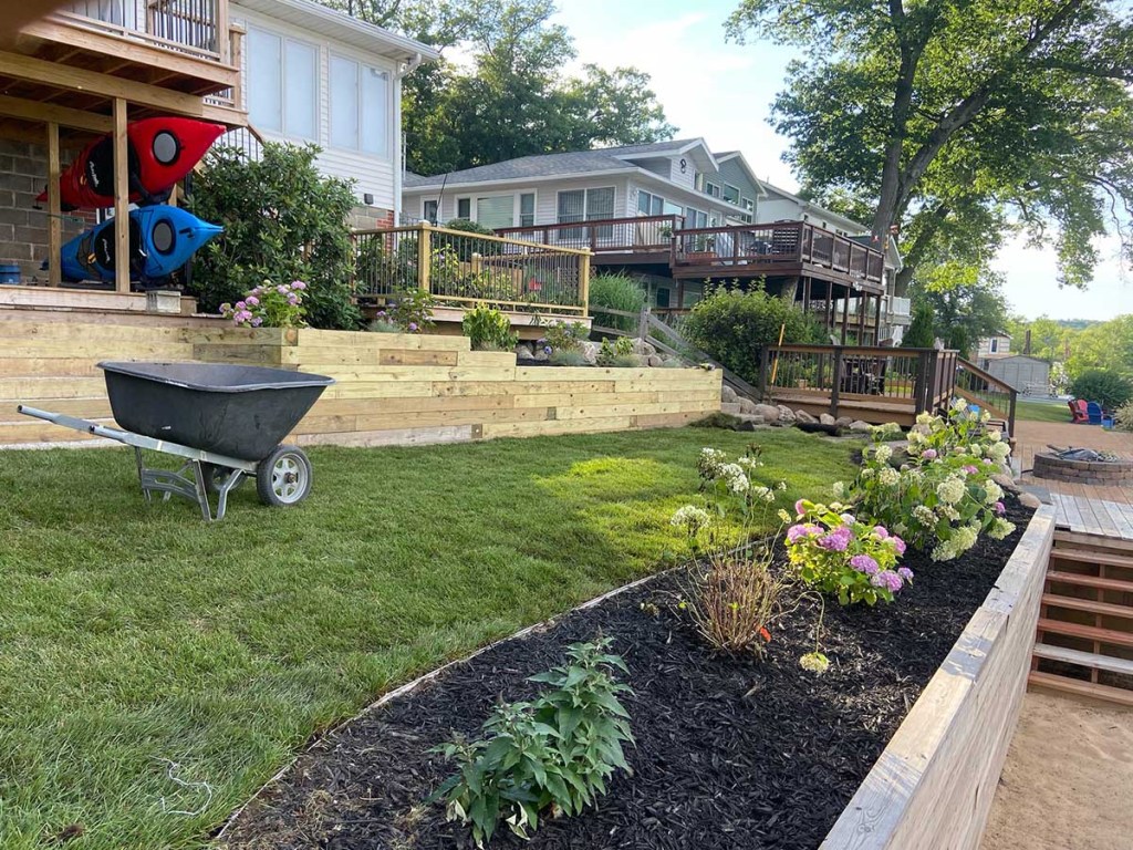 Fertilized lawn with a retaining wall and barrier garden